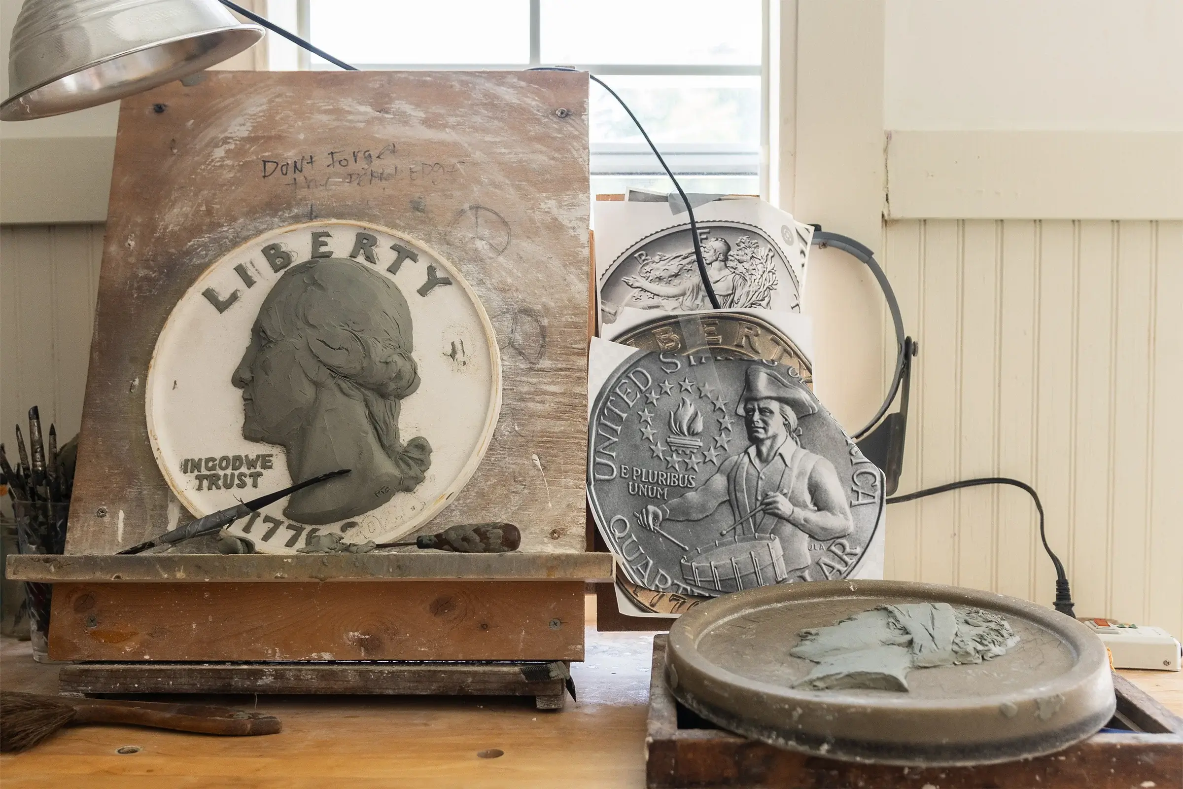Michael Gaudioso's home studio with Bicentennial Quarter clay work and reference images